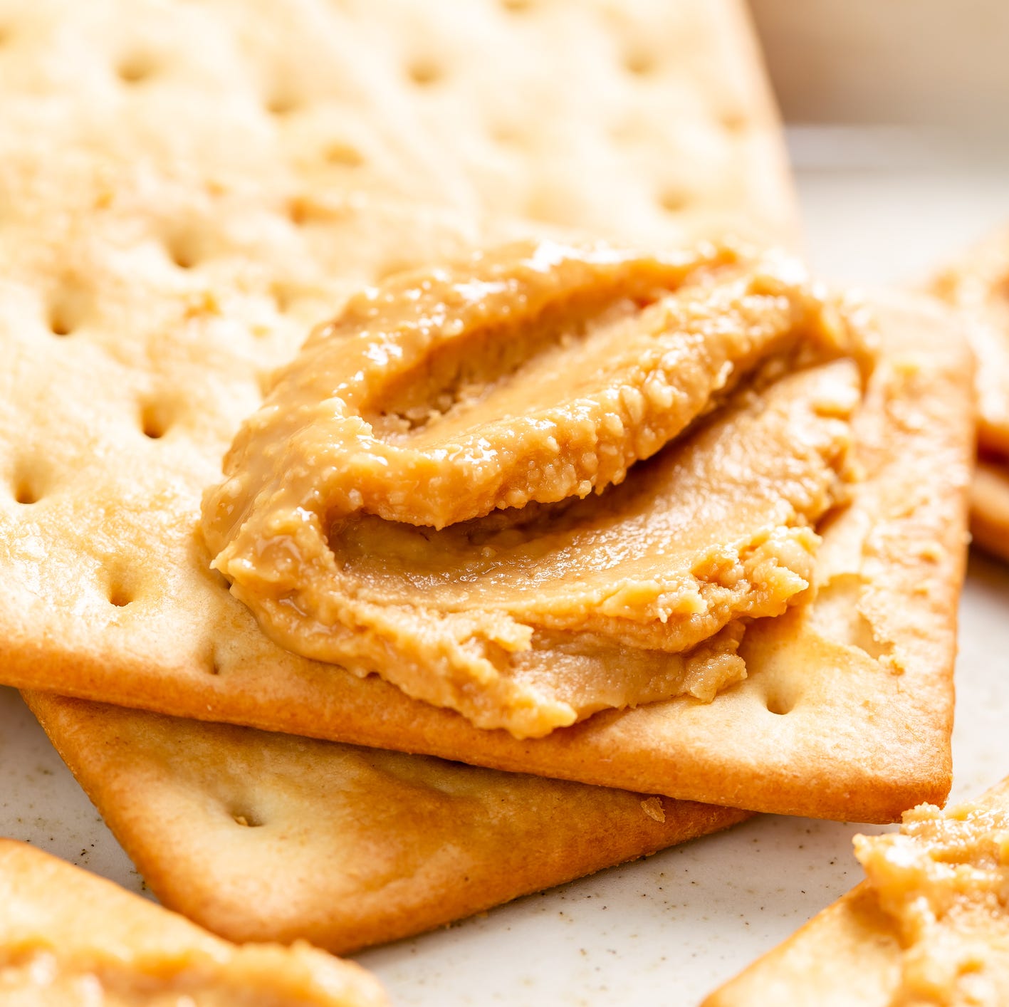 peanut butter spread on soda crackers close up