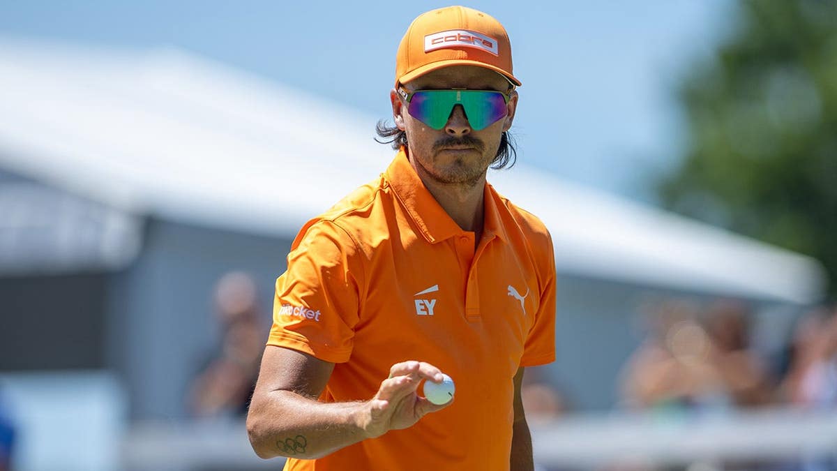 Rickie Fowler motions to the crowd after putting on the ninth hole at Quail Hollow Country Club