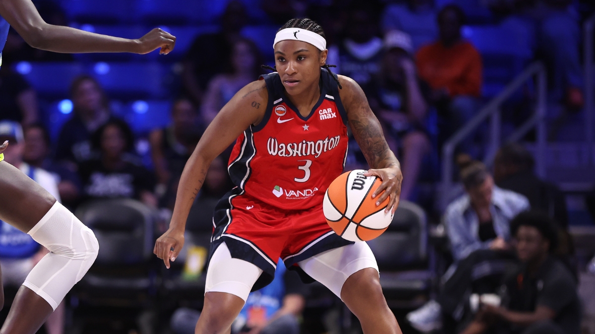 Washington Mystics guard Rori Harmon driving the ball along the perimeter as Dallas Wings forward Awak Kuier uses her length to close down the lane defensively.