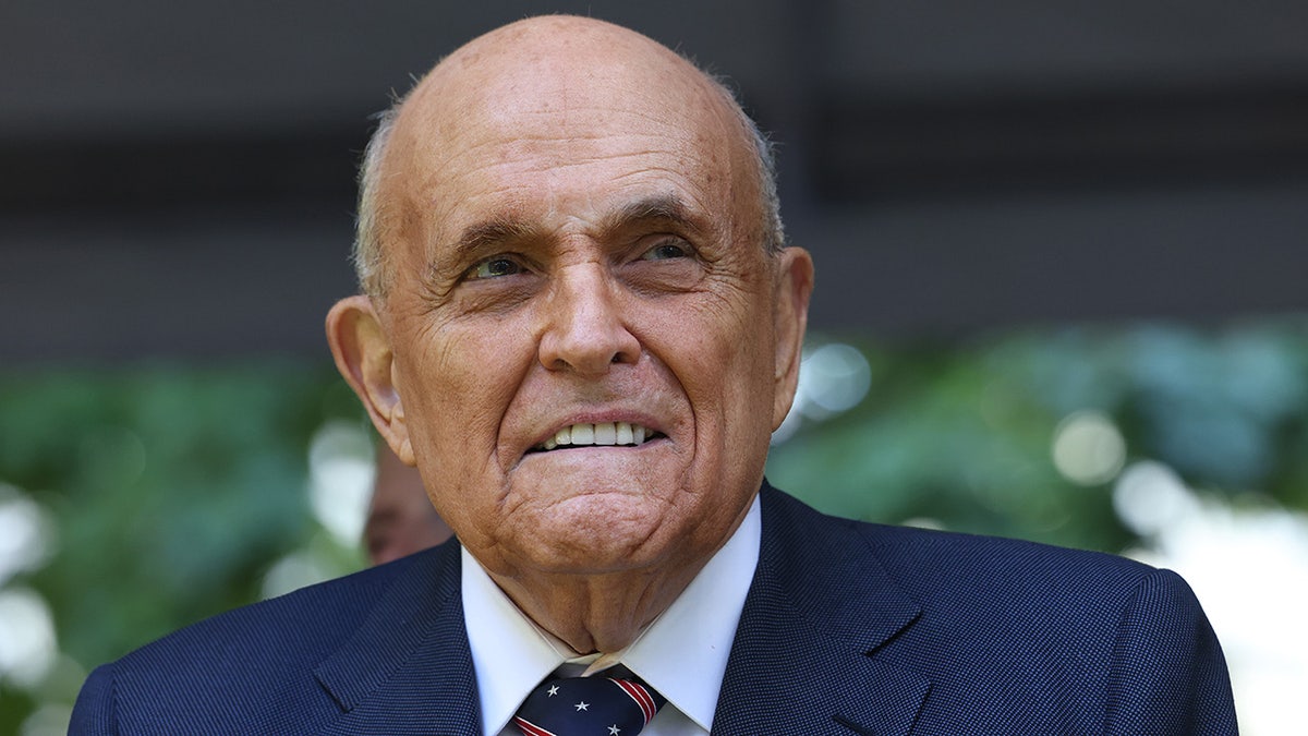 Former NYC Mayor Rudy Giuliani standing at the National 9/11 Memorial and Museum in New York City