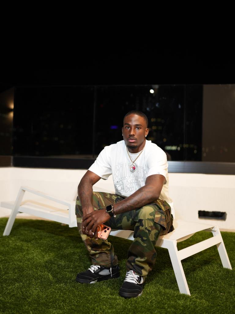 Sam Houston State defensive back William Davis sitting on a white lounge chair on artificial grass.