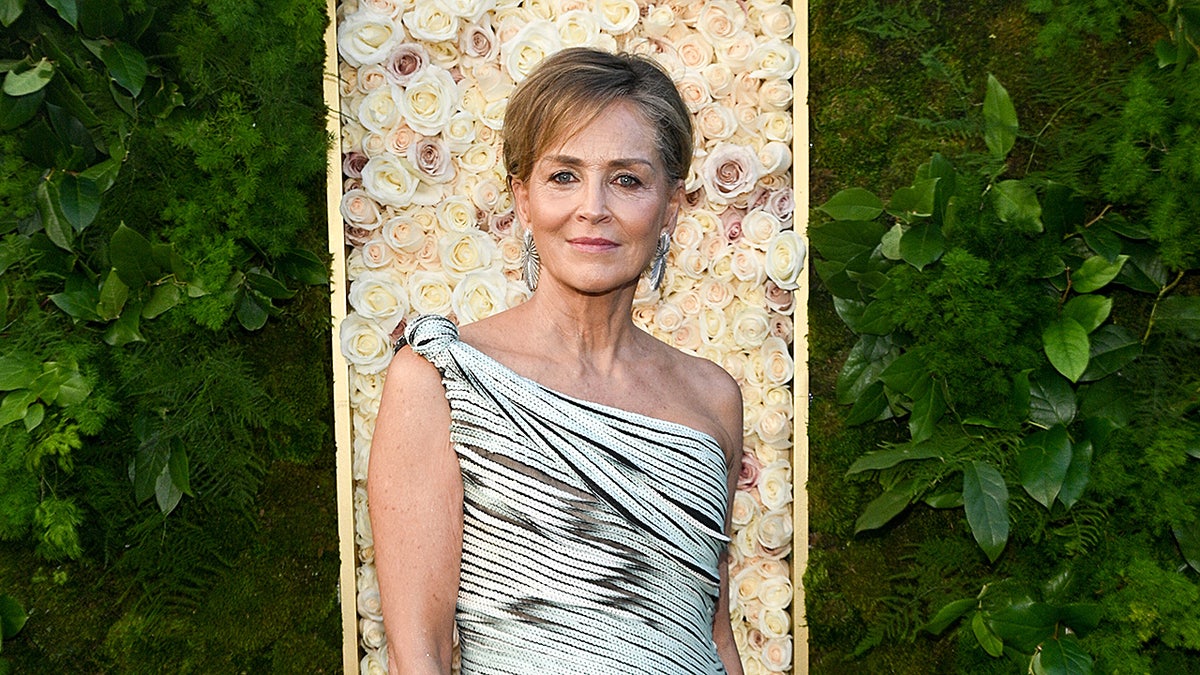 Sharon Stone standing in an off-shoulder dress at the Golden Globes event