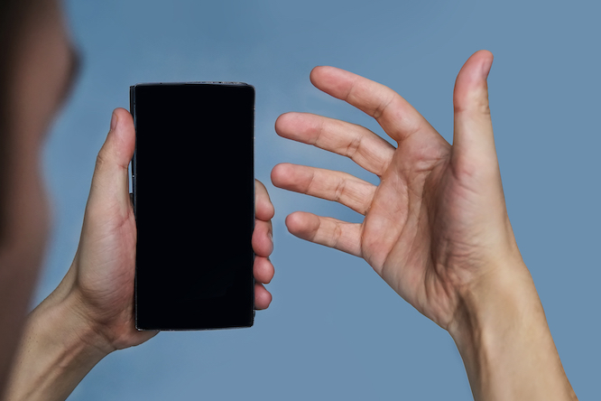The guy looks at his phone with confusion. Talking on video chat on mobile. Blank for image. The black phone.