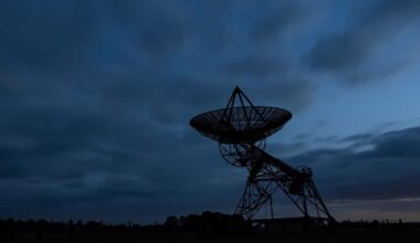 Silhouette Photo Of A Radio Telescope Antenna In A Field At Dusk