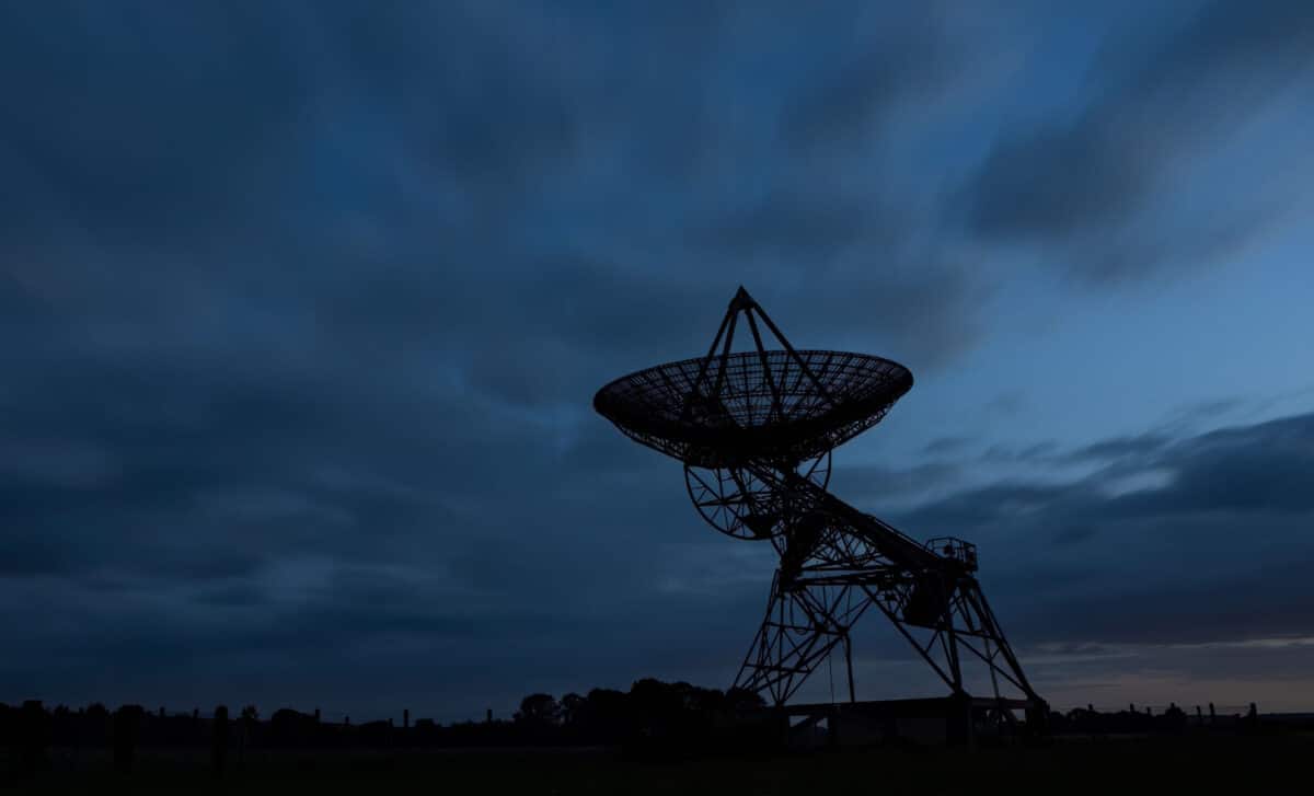 Silhouette Photo Of A Radio Telescope Antenna In A Field At Dusk