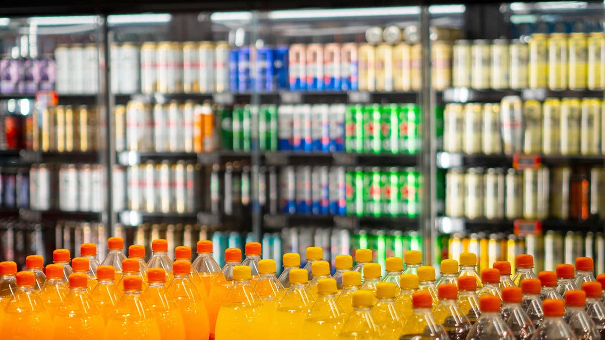 A variety of sodas are displayed at a grocery store.