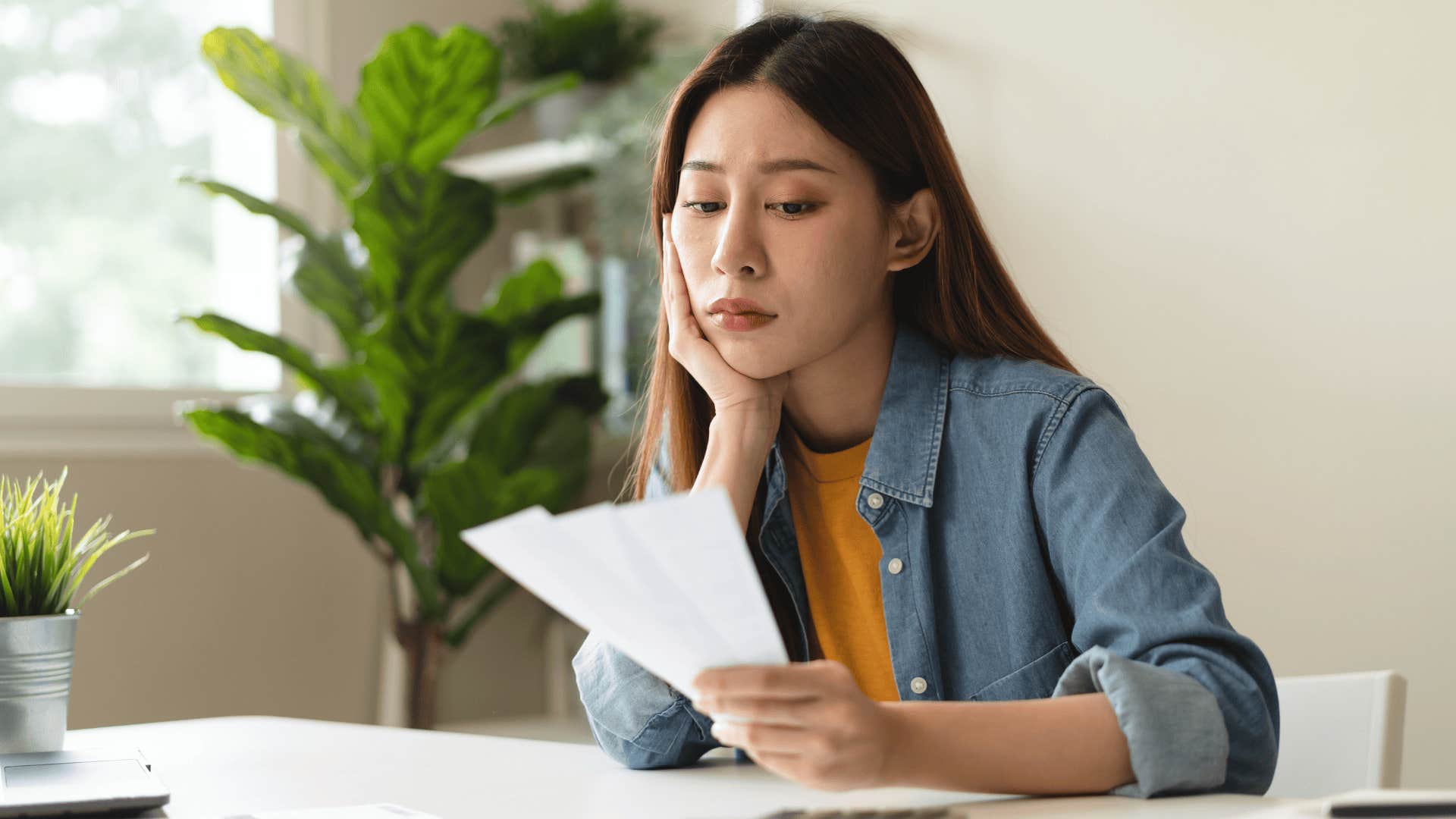 woman looking at bills unable to have disposable income