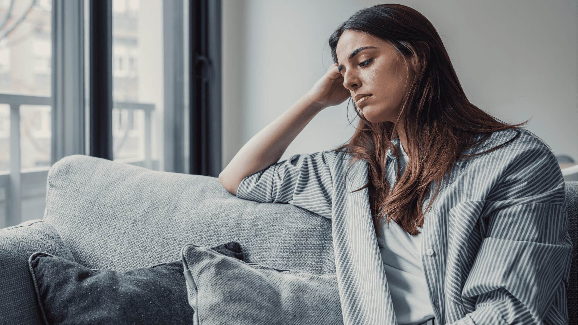 stressed woman sitting at home unable to afford a vacation