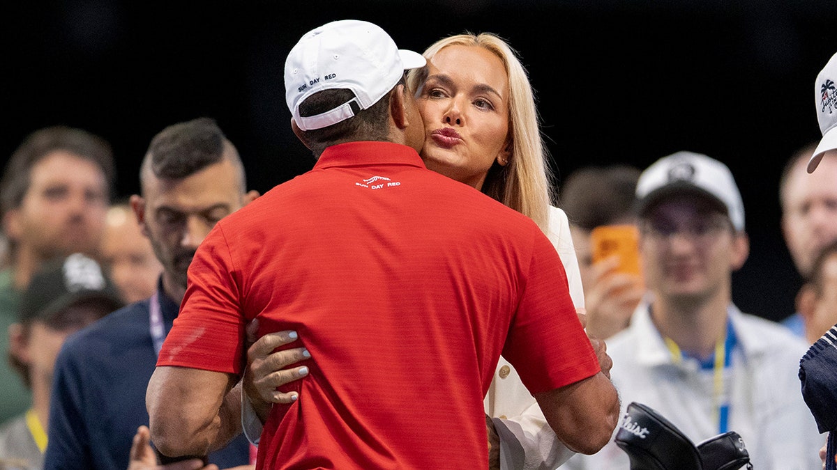 Tiger Woods receiving a hug and kiss from Vanessa Trump at SoFi Center