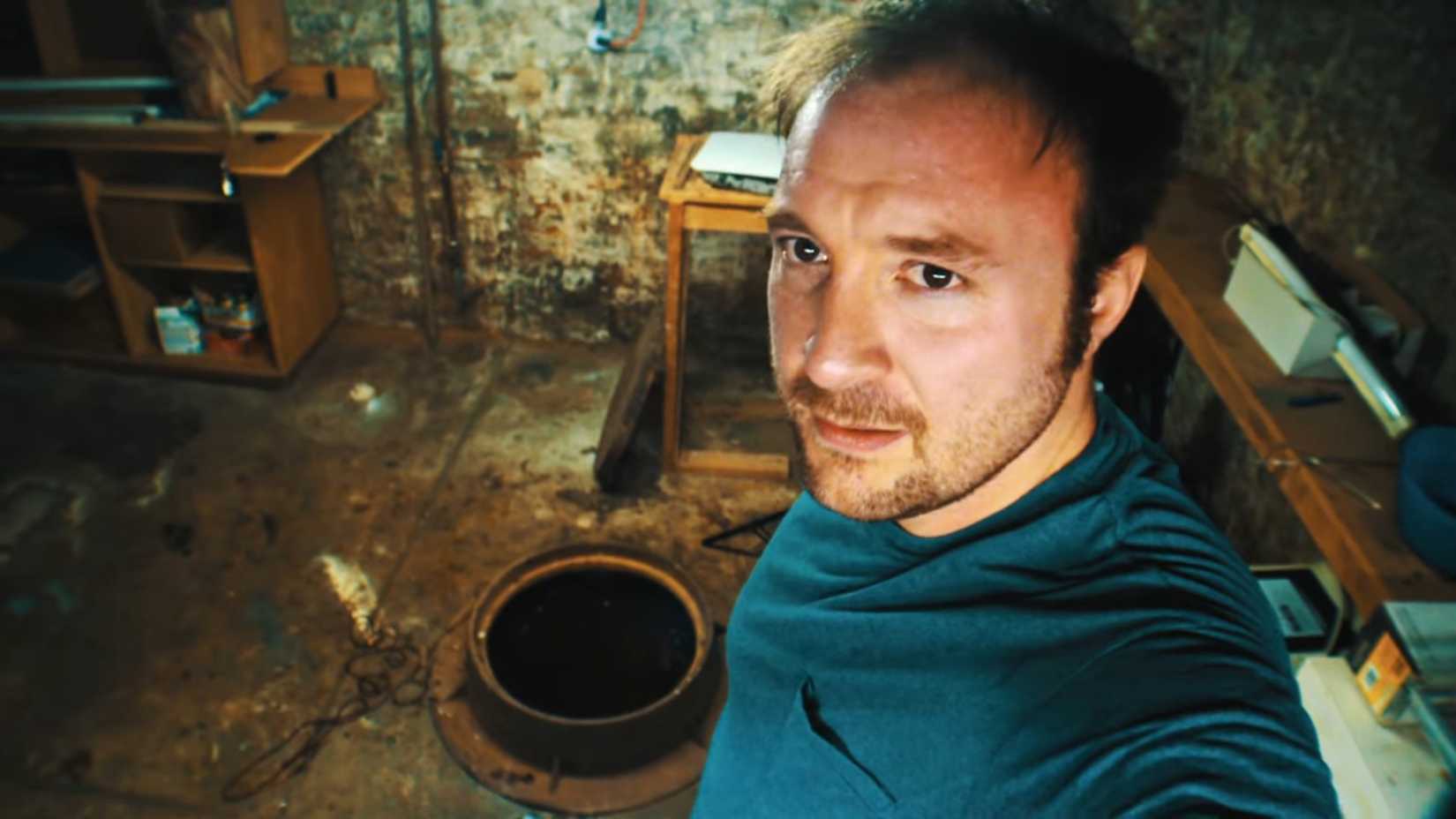 Turner Clay standing over a strange well in the basement of a house in The Blackwell Ghost