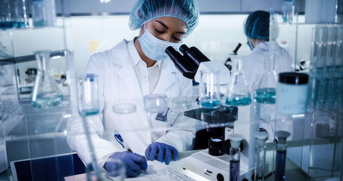 Researchers in protective equipment working in a pharmaceutical lab.