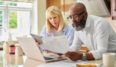 Couple looking at documents and laptop together.
