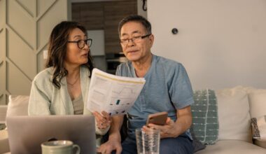 People sitting on a sofa, reviewing financial papers.