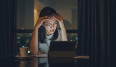 Concerned young person with head in hands gazing at a screen.