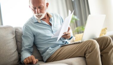 Serious person holding documents and using calculator.