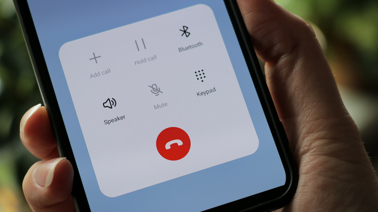a person holding a phone that shows a call on screen