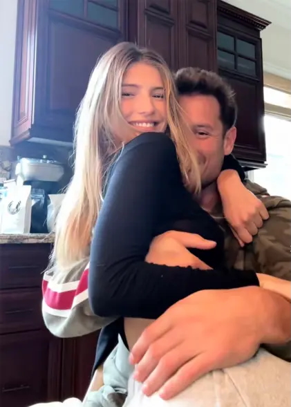 Nick Bosa embracing a woman in a kitchen setting.