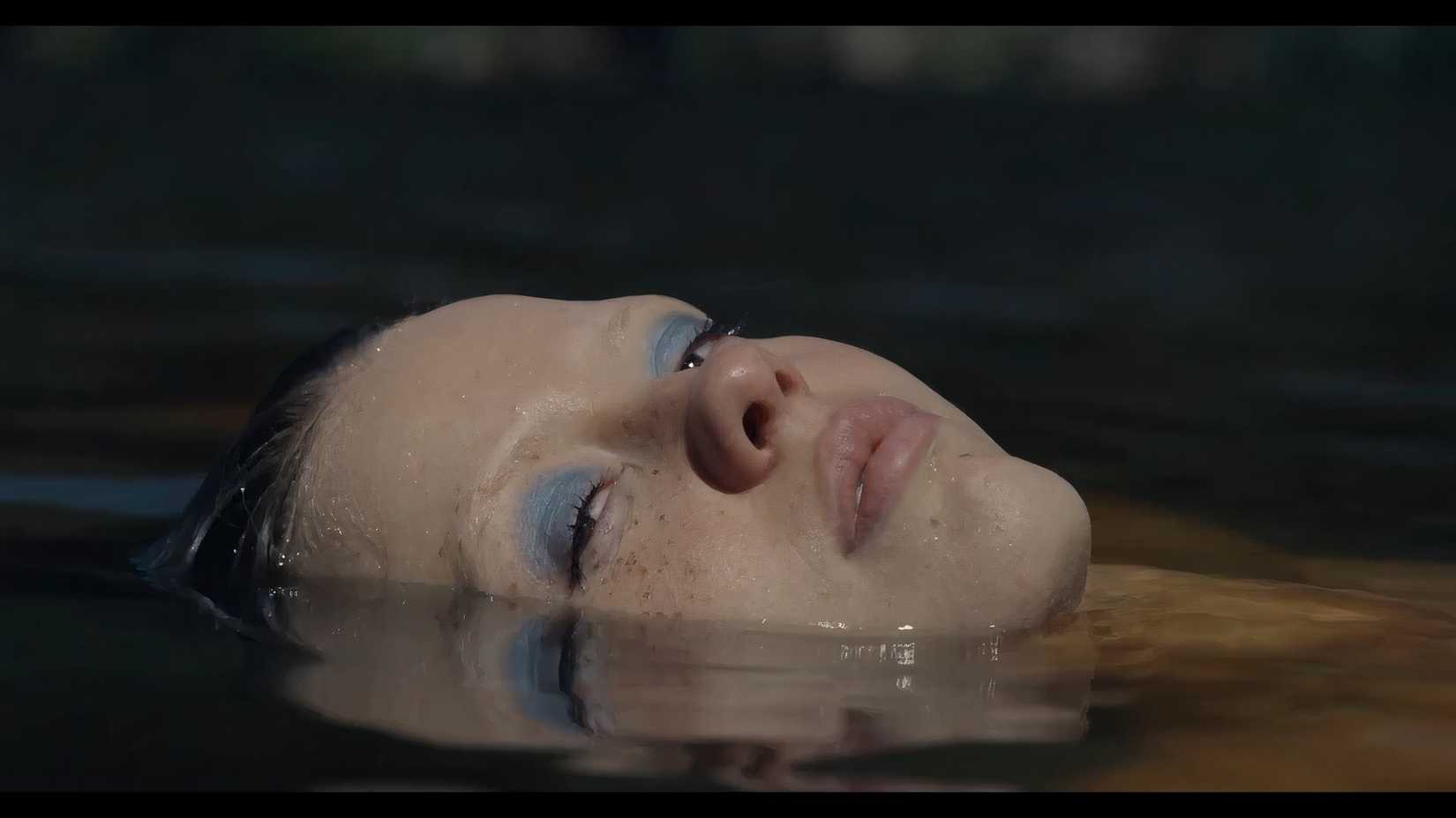Pearl, played by Mia Goth bathes in a lake from X