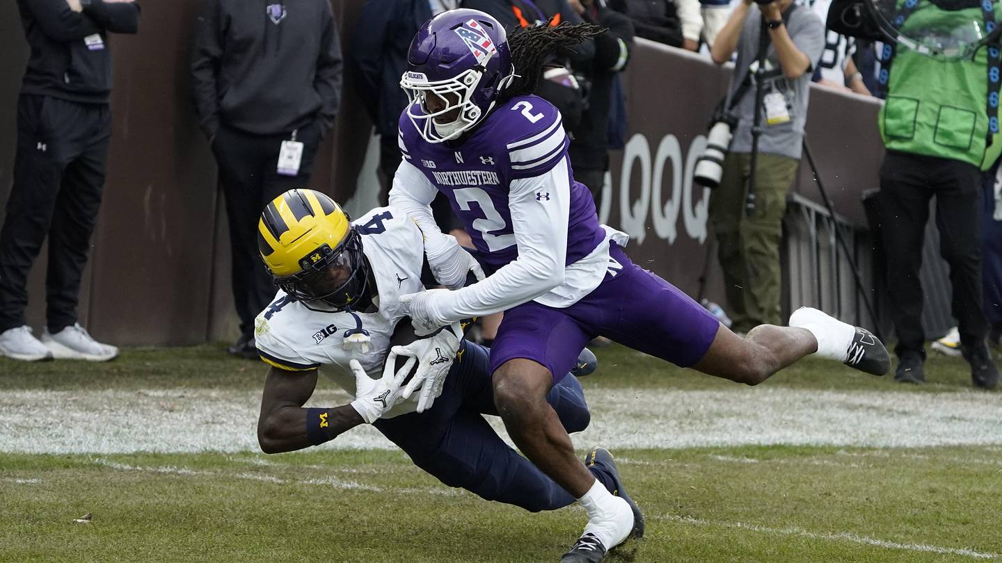 Nov 15, 2025; Chicago, Illinois, USA; Michigan Wolverines wide receiver Andrew Marsh (4) makes a catch as Northwestern Wildcats cornerback Fred Davis II (2) defends him during the first half at Wrigley Field. Mandatory Credit: David Banks-Imagn Images
