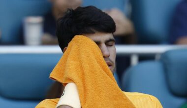 Carlos Alcaraz wipes his face in his player's chair during a changeover