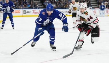 Oct 16, 2023; Toronto, Ontario, CAN; Toronto Maple Leafs left wing Matthew Knies (23) and Chicago Blackhawks defenseman Wyatt Kaiser (44) chase down the puck during the first period at Scotiabank Arena. Mandatory Credit: Nick Turchiaro-Imagn Images