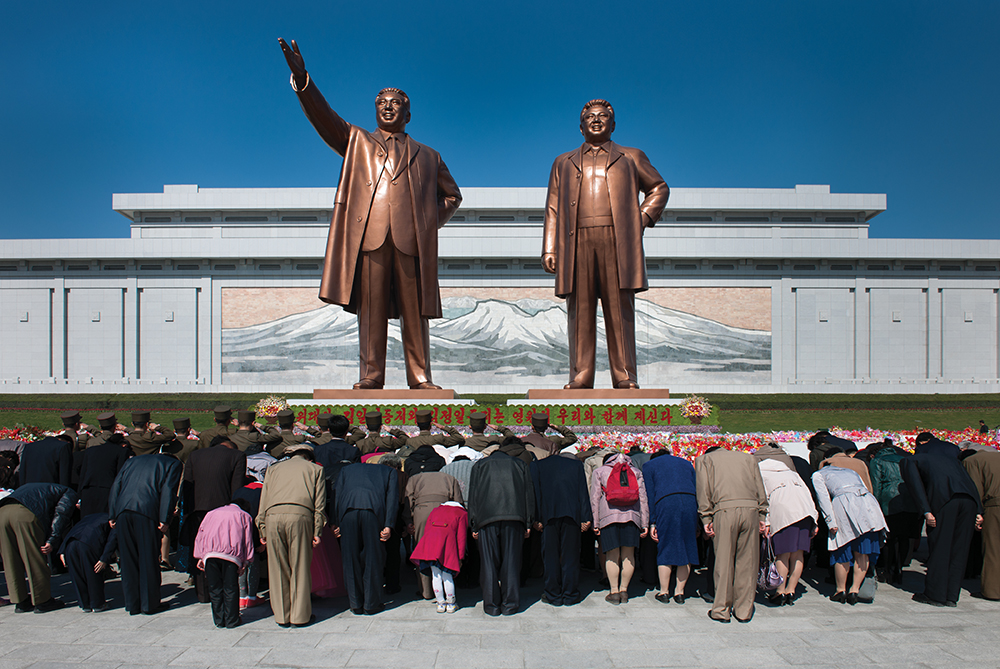North Korea, Pyongyang – April 16, 2012: North Koreans bow to the newly unveiled statues of Kim Il Sung and Kim Jong Il in Pyongyang at the Mansudae Grand Monument.