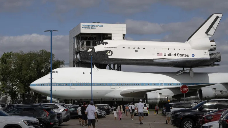 A space shuttle replica sits mounted on the original NASA 905 shuttle carrier aircraft at the Houston Space Center.