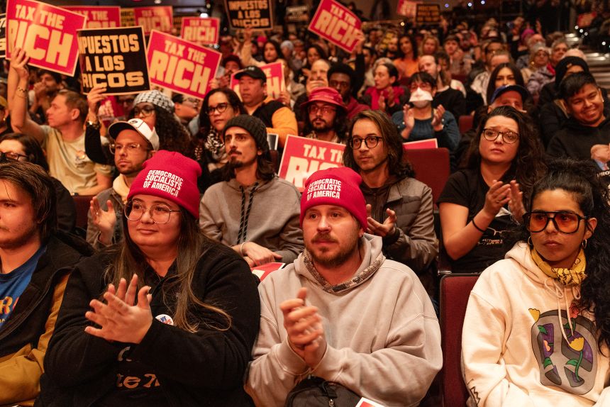 People attend a Tax The Rich rally hosted by the Democratic Socialists of America, featuring Sen. Bernie Sanders, , at Lehman College in the Bronx borough of New York, on March 29.