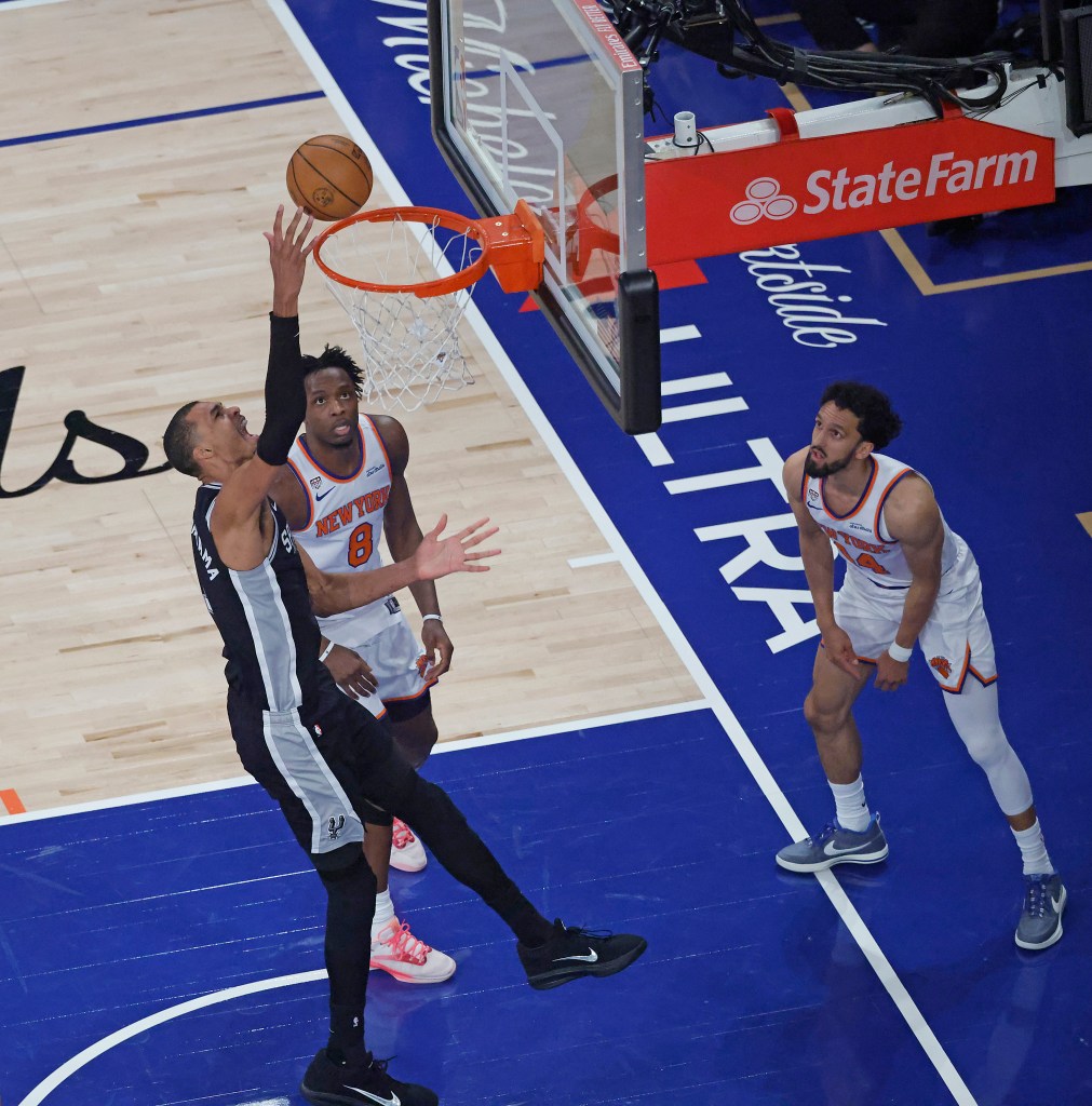 San Antonio Spurs forward Victor Wembanyama (1) puts up a shot as New York Knicks forward Og Anunoby (8) and New York Knicks guard Landry Shamet (44) watch during the first quarter.