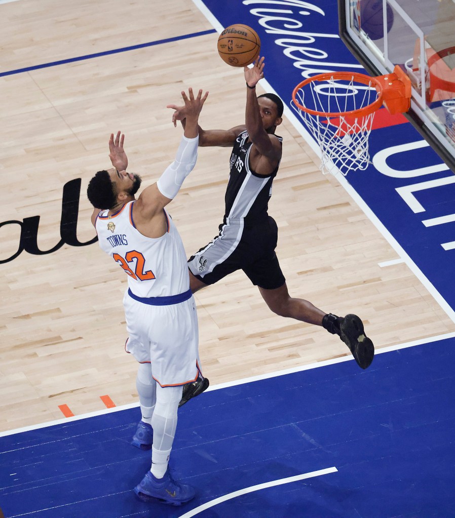 New York Knicks center Karl-Anthony Towns (32) fouls San Antonio Spurs guard De'aaron Fox (4) during the first quarter.