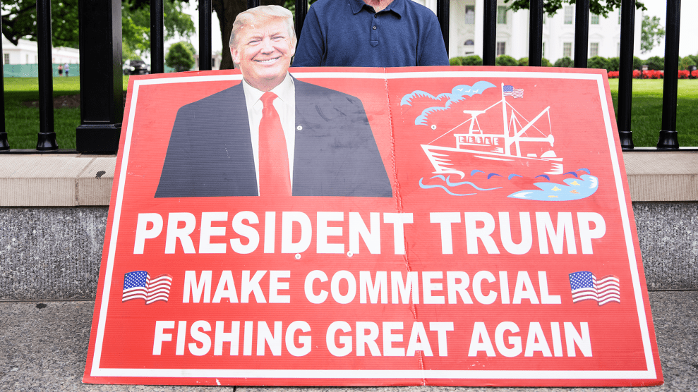 Red sign with white lettering has picture of Donald Trump in suit and red tie. The sign reads "President Trump Make Commercial Fishing Great Again."