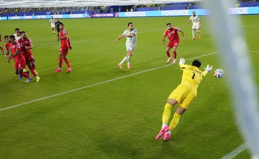 Algeria's Nadhir Benbouali scores their first goal against Jordan.
