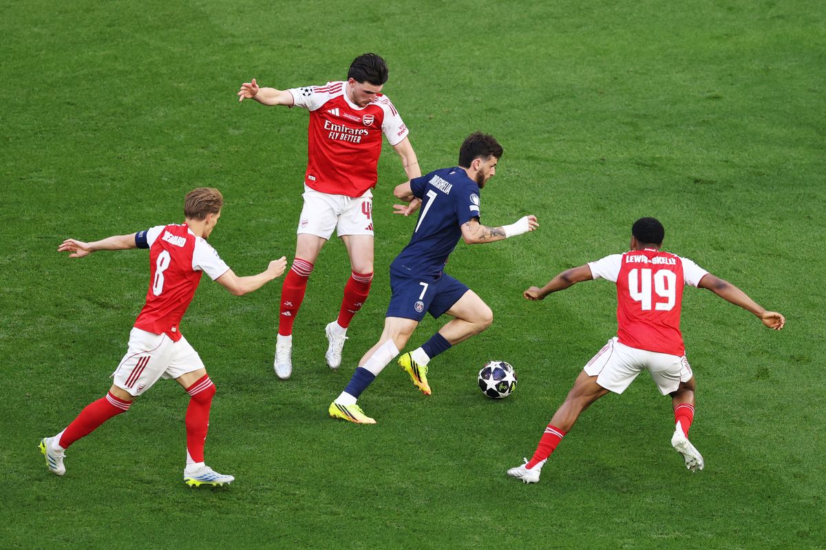 Khvicha Kvaratskhelia of Paris Saint-Germain is challenged by Declan Rice, Martin Odegaard and Myles Lewis-Skelly of Arsenal during the UEFA Champions League Final 2026 match between Paris Saint-Germain and Arsenal FC at Puskas Arena on May 30, 2026 in Budapest, Hungary