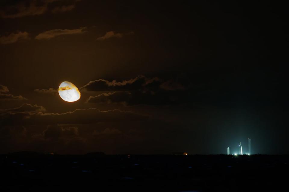 Long distance shot of a launchpad with the moon in the background