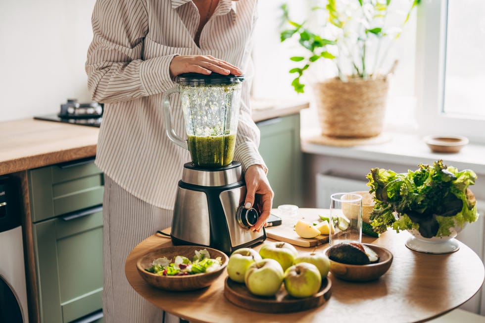 Woman is preparing a healthy green smoothie woman is preparing a healthy green smoothie