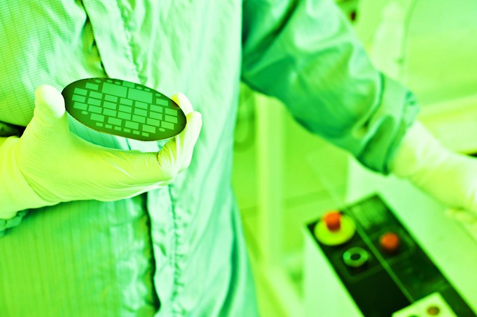 Lab technician holding wafer.