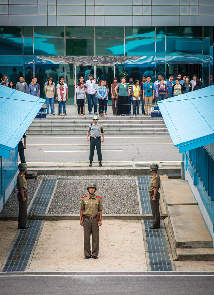 Tourists visit the Joint Security Area at Panmunjeom with North Korean soldiers in the foreground and South Korean troops in the background on September 16, 2014. The South Korean government on December 9, 2024 ordered an overseas travel ban on President Yoon Suk Yeol as he faces investigation on possible rebellion charges over the recent emergency martial law declaration. Opposition lawmakers continue to pursue impeachment for Yoon who accused the opposition-controlled parliament of paralyzing the government and sympathizing with communist North Korea, with whom South Korea technically remains at war..