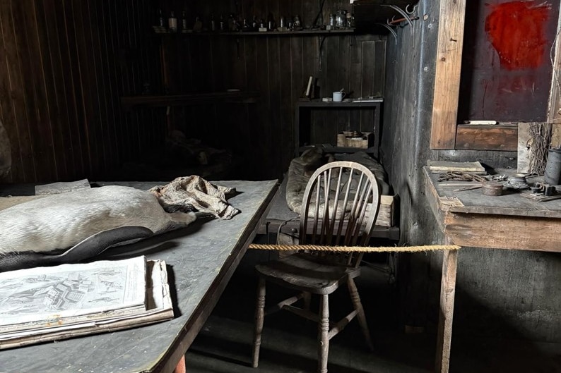 Inside Scotts hut a rope between two wooden tables blocks access to chemicals.