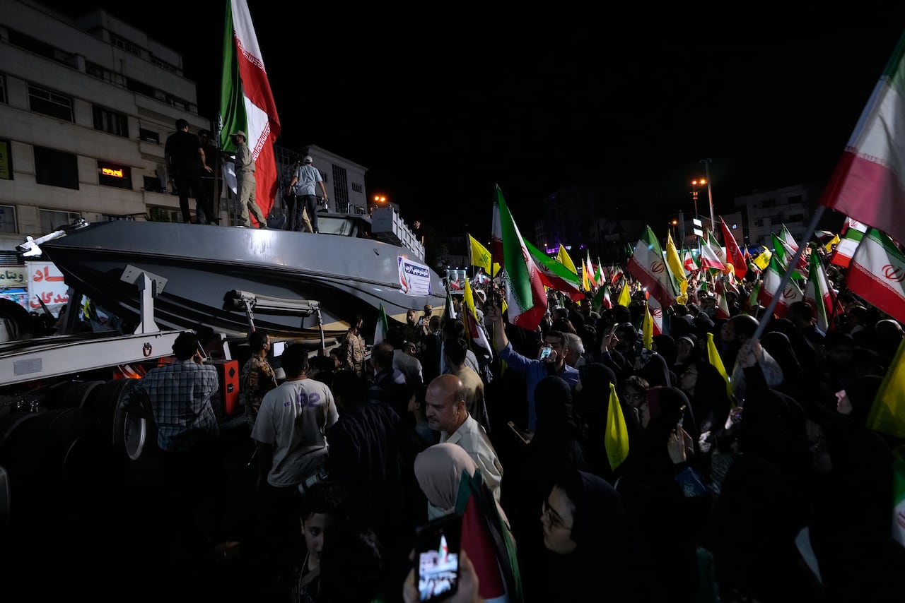 A nighttime demonstration is shown, with people holding flags and a boat displayed.