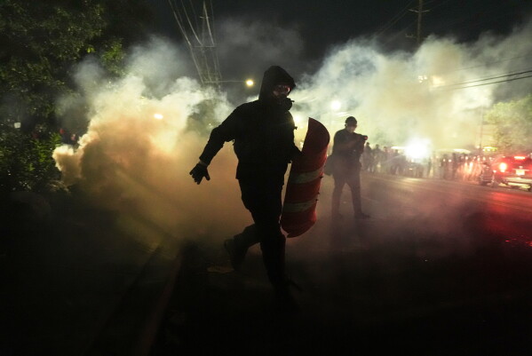 Anti-ICE protesters disperse during clashes with law enforcement officers outside the Delaney Hall detention center on Saturday, May 30, 2026, in Newark, N.J. (AP Photo/Angelina Katsanis)