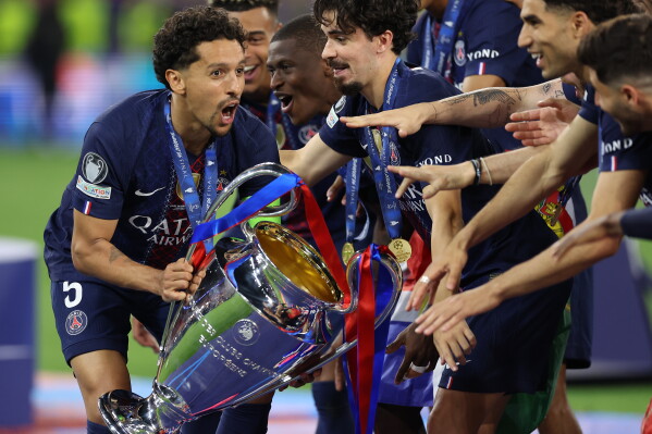 PSG players celebrate with a trophy after the Champions League final soccer match between Paris Saint-Germain and Arsenal in Budapest, Hungary, Saturday, May 30, 2026. AP Photo/Armin Durgut)