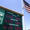 An American flag on a tall flagpole flies above a sign displaying gas prices in red digital numbers at a gas station in Arcadia, California, on May 11.