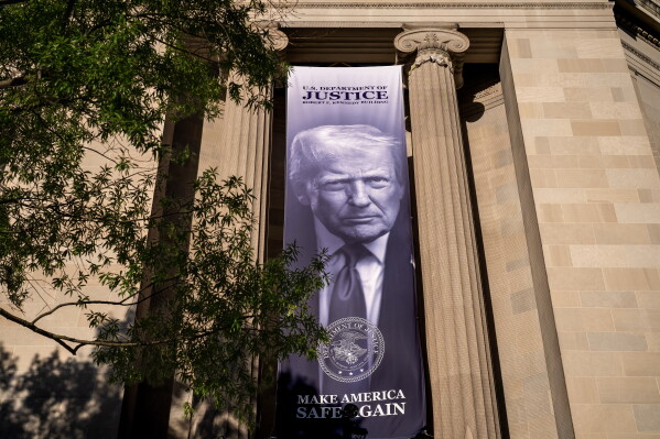 A giant portrait of President Donald Trump looks down from the Justice Department in Washington, Tuesday, June 2, 2026. The Justice Department said it would comply with a court order pausing the implementation of a $1.776 billion settlement fund designed to compensate President Donald Trump's political allies after GOP senators revolted. (AP Photo/J. Scott Applewhite)