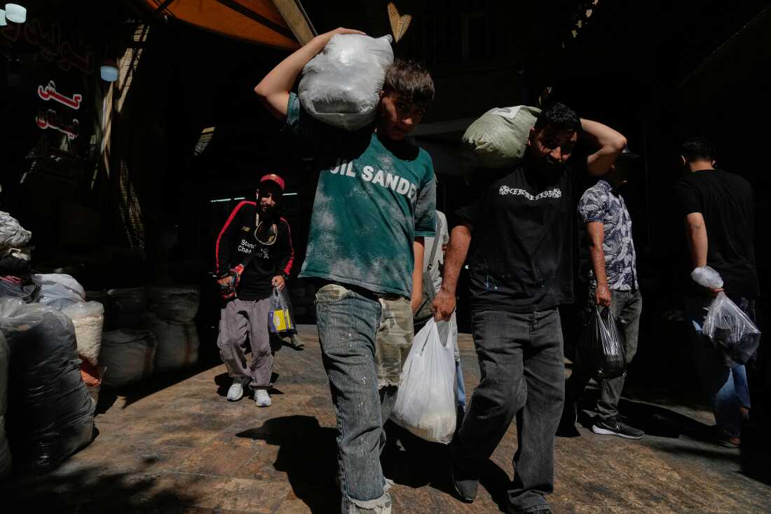 People carry packages at Tehran's historic Grand Bazaar, Iran, Monday, June 1, 2026.
