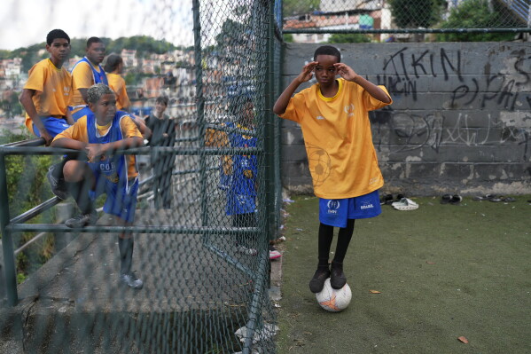 Luis Gustavo balances on a ball during a soccer training session organized by the Street Child United Brazil social project in the Complexo da Penha favela of Rio de Janeiro, Wednesday, June 3, 2026. (AP Photo/Silvia Izquierdo)