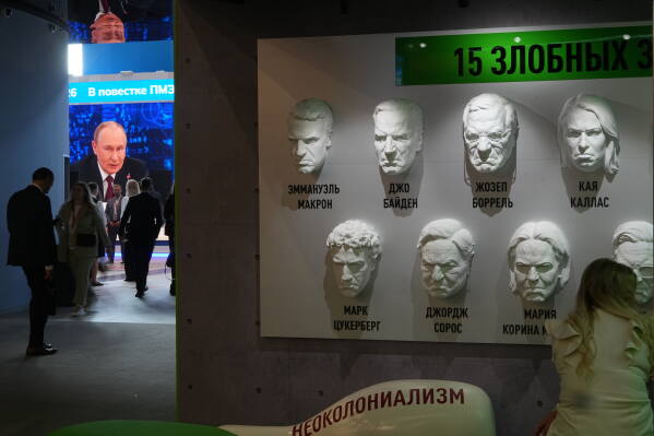 Face bas-reliefs depicting Western politicians and businessmen and a sign reading "15 evil spectators of Russia Today" displayed at the stand of Russia Today TV company at an exhibition at the St. Petersburg International Economic Forum in St.Petersburg, Russia, Wednesday, June 3, 2026. (AP Photo/Dmitri Lovetsky)