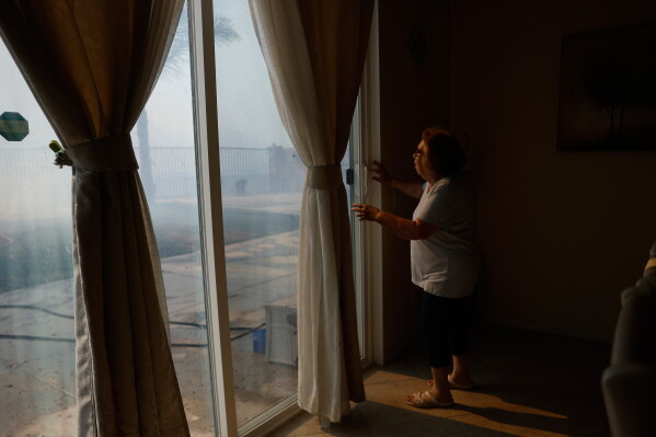 Mayra Long looks from inside her home as the Sandy Fire approaches May 19, 2026, in Simi Valley, Calif. (AP Photo/Caroline Brehman, File)