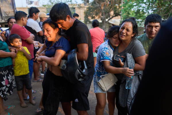 Relatives of Jose Perez mourn as police recover his body from a ravine where he was found shot in Trujillo, Peru, Friday, May 30, 2026. (AP Photo/Rodrigo Abd)