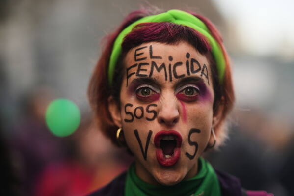 A demonstrator poses for a photo with her face painted in Spanish, "The femicide-committer is you" during a march marking the anniversary of the "Ni Una Menos" (Not One Fewer) women's movement in Buenos Aires, Argentina, Wednesday, June 3, 2026. (AP Photo/Natacha Pisarenko)