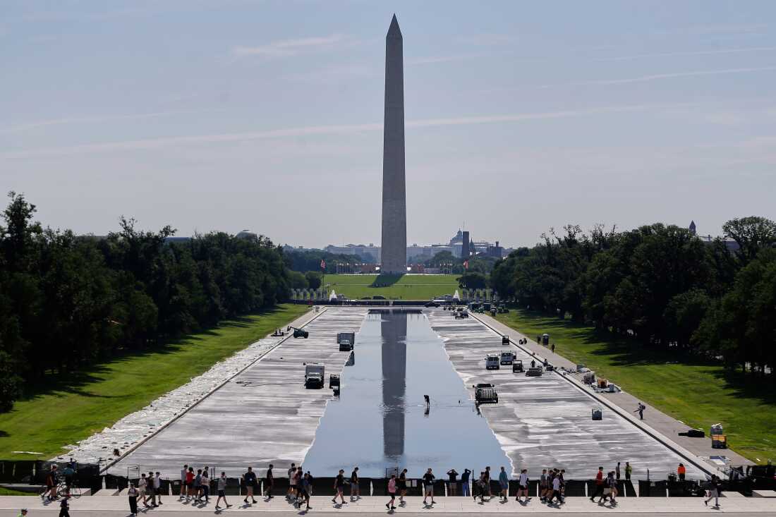 Workers refill the Lincoln Memorial Reflecting Pool on Friday, after weeks of resurfacing.